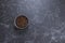 Coffee beans in dark bowl cup on isolated dark textured background