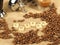 Coffee beans, glass mug, tamper in front of a group handle with the letters coffee on a hessian background