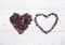 Coffee beans in heart shape on wooden background.