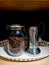 Coffee beans inside a glass jar with an aluminum tray on the right side to pour the liquid coffee