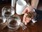 Coffee beans from a pack on a palm above a table with coffee subjects. Cappings