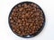 Coffee beans on the plate over white background