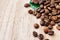 Coffee beans scattered on a light wooden table, top view, closeup grains, place to insert text, copy space