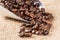 Coffee beans scattered of metallic scoop on sacking surface
