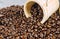 Coffee beans in small wooden bucket with coffee beans background