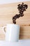 Coffee beans smoke floats from the coffee mug