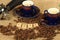 Coffee beans, two ornate cups and group handle with the letters love on a hessian background