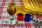 Coffee being filtered through a cloth strainer in enameled cups and homemade bread in the background on a checkered tablecloth. Ma