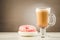 Coffee break: cappuccino glass with fresh sugary pink donut/Coffee break: cappuccino glass with fresh sugary pink donut on a gray