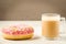 Coffee break: cappuccino glass with fresh sugary pink donut/Coffee break: cappuccino glass with fresh sugary pink donut over white