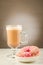 Coffee break: cappuccino glass with fresh sugary pink donut/Coffee break: cappuccino glass with fresh sugary pink donut. Selective