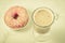 Coffee break: cappuccino glass with fresh sugary pink donut/Coffee break: cappuccino glass with fresh sugary pink donut on a white