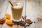 Coffee break with cold iced latte and beans on wooden table background