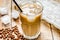 coffee break with cold iced latte and beans on wooden table background