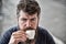 Coffee break concept. Man with long beard looks calm and relaxed. Bearded man holds espresso cup, drinks coffee. Man