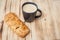 Coffee break in the country with cup of freshly brewed coffee with milk and croissan on wooden table top with copyspace