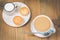 Coffee break. Muffins and blue mug with cappuccino and cream in a small cup for breakfast on a wooden table. Top view