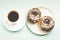 Coffee break. White cup with black coffee and donat in glaze. Top view