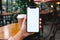 Coffee break Woman holds mobile phone with blank desktop screen