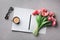 Coffee, clean notebook, eyeglasses and beautiful flower on stone table top view in flat lay style. Woman working desk.