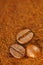 Coffee - coffee beans on ground coffee. Large close-up of the bean. Brown, warm colors of the image. Worn and dried coffee under