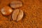 Coffee - coffee beans on ground coffee. Large close-up of the bean. Brown, warm colors of the image. Worn and dried coffee under