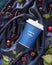 Coffee composition with craft cup of cherry latte, cherries and leaves on a blue, satin, folded background