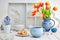 Coffee and cookies on white table with red tulips and springtime decorations