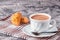 Coffee with cream and freshly baked puffs on a gray background