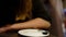 Coffee. Cropped young caucasian woman in black drinking coffee in restaurant, cafe. Closeup woman hands with white cup