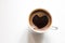 Coffee in a cup, aromatic drink with foam on the surface in the shape of a heart