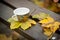 Coffee cup on the bench in autumn day.Coffee cup and leaf  on wooden table outdoor background.