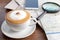 Coffee cup of cappuccino besides with smartphone