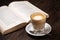 Coffee cup cappuccino hot latte or coffee with milk in a glass cup, open book