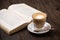 Coffee cup cappuccino hot latte or coffee with milk in a glass cup, open book