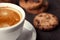 Coffee cup with chocolate cookies on dark old wooden table