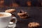 Coffee cup with chocolate cookies on dark old wooden table