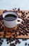 Coffee in cup and coffee bean on rustic table with a blank space for a text