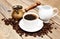Coffee cup with coffee beans, milk jug and turk on a wooden b