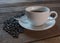 Coffee cup and coffee beans on old wooden table background