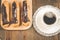 Coffee cup and eclairs/coffee cup and eclairs on a wooden table. Top view