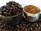 Coffee cup filled with coffee beans, portafilter filled with ground coffee, coffee beans scattered between the scarf and porta