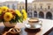 A coffee cup and flowers on a table beside a balcony at sunrise