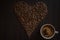 Coffee cup full of coffee and roasted coffee beans on wooden table in the form of hearth