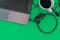 Coffee cup and headphones from  laptop computer  on a green bright tone background. Top view