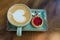 coffee cup with heart shape with strawberry biscuit on blue plat