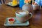 coffee cup with heart shape with strawberry biscuit on blue plat