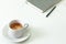 Coffee cup , laptop and grey notpad on white table. Selective focus