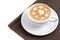 Coffee cup of latte art, many heart shapes on top, place on napkin on white background isolated