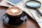 Coffee cup of latte art beside with smartphone